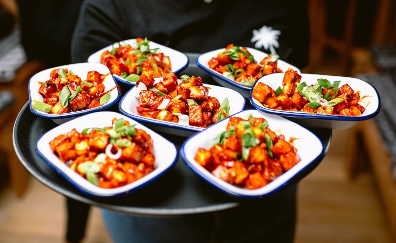Person holding tray of food - credit The Coconut Tree